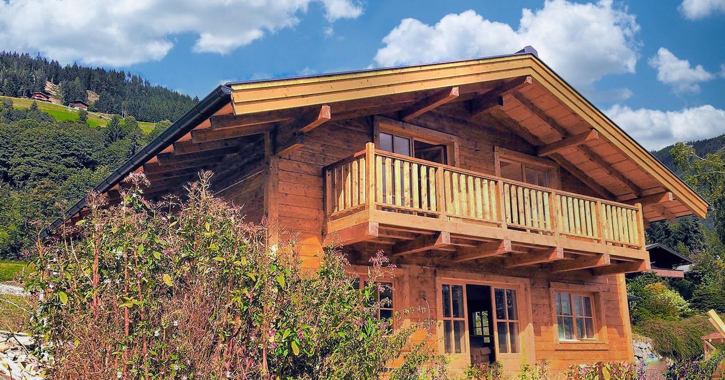 Casă din lemn cu acoperiș tipic austriac, construită de Aceris, situată într-o zonă cu case pe dealuri în Austria